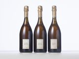 three bottles of wine sitting on top of a white table