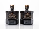 two bottles of sexton single malt whiskey on a white surface