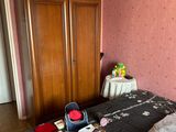 a bed with a black comforter and a wooden armoire
