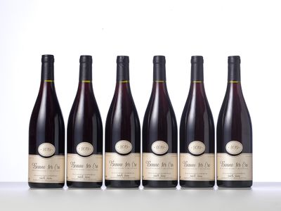 six bottles of wine lined up in a row on a table