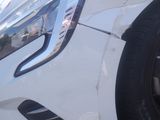 a close up of a white car parked in a parking lot