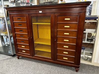 une armoire en bois avec une porte vitrée et des étagères jaunes