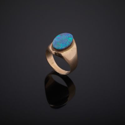 a gold ring with an oplite stone in the center