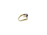 a close up of a gold ring with a blue stone