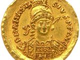 a close up of a gold coin on a white surface