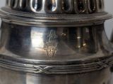 a silver tea pot with a lid on a table