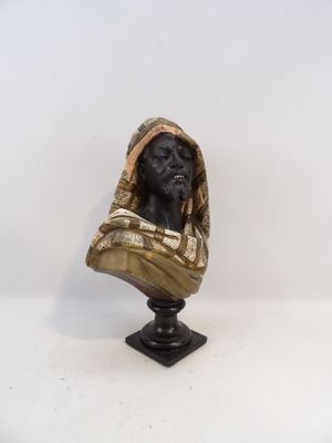 une statue représentant un chien portant une couverture, posée sur une table