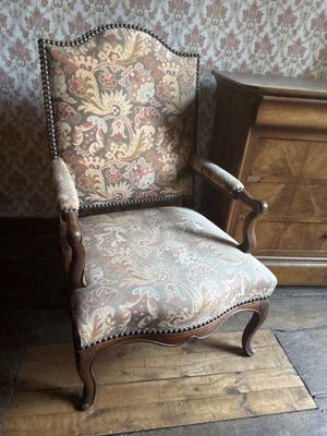 a chair that is next to a dresser in a room