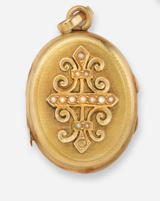 une image représentant un fer à friser en or orné d'une croix et de perles