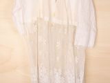 an image of a white dress hanging on a wooden wall