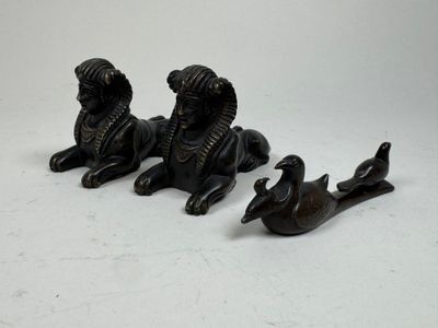 three figurines of animals that are sitting on the ground
