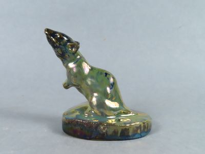 une petite statue représentant un rat, posée sur un socle