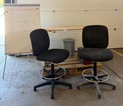 two office chairs sitting on a pallet in a garage