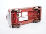a red toy bus that is sitting on a white surface