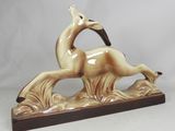 figurine représentant un cheval au galop, posée sur un socle en bois