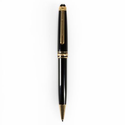 a black and gold ballpoint pen sitting on top of a white surface