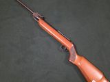 un fusil posé sur une surface verte, sur fond noir