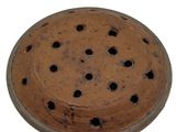 a brown bowl with holes in it on a white surface