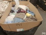 a cardboard box full of clothes on the floor