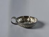 a small silver bowl with a handle on a table