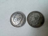 two silver coins, one with a woman ' s face and one with a man ' s head
