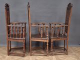 two wooden chairs sitting next to each other on a wooden floor