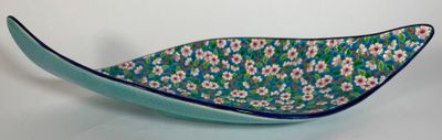 blue and white bowl with flowers on it on a white surface
