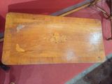 a small wooden table with a flower design on it