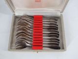 six spoons in a box with a red ribbon