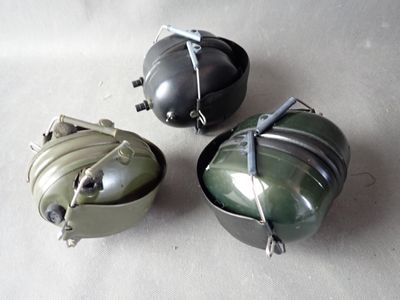 three small metal containers sitting on a white surface