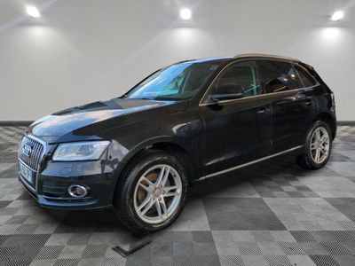 un SUV Audi noir garé sur un sol à damier dans un garage