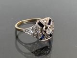 an image of a diamond and sapphire ring on a reflective surface