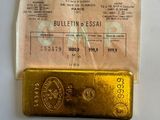 a gold bar sitting on top of a piece of paper