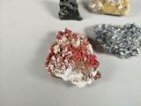 several different colored rocks are arranged on a white surface
