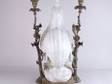 an image of a statue of a woman sitting on top of a table next to two candles