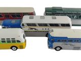 quatre petits bus qui sont rangés les uns à côté des autres