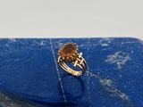 un gros plan d'une bague sertie d'une pierre bleue et dotée d'un anneau en or