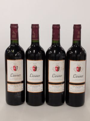 quatre bouteilles de vin sont alignées sur une surface blanche