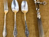 quatre cuillères, une fourchette et un couteau sur une table