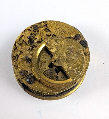 une assiette en or ornée d'une horloge, posée sur un fond blanc