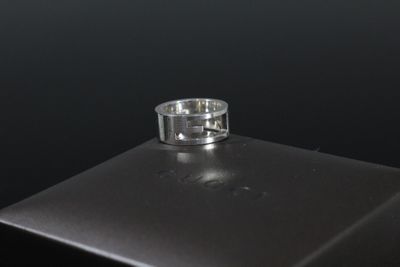 gros plan d'une bague en argent sur une surface noire