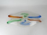 four different colored glass spoons on a white surface