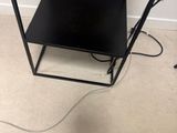 un micro-ondes posé sur une petite table noire