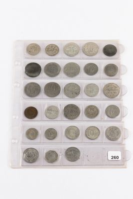 an assortment of coins in a plastic case on a white surface