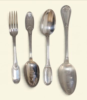four spoons and a fork on a white surface