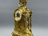 a gold clock sitting on top of a table
