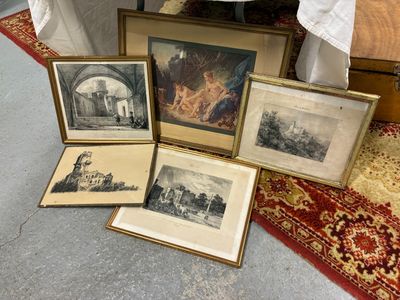 quatre photos encadrées posées par terre à côté d'un lit