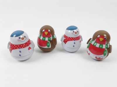 three small wooden snowmen sitting next to each other on a white surface