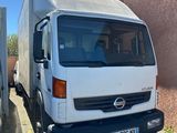 un camion blanc garé à côté d'un immeuble