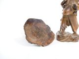 a statue of a man holding a bag next to a rock